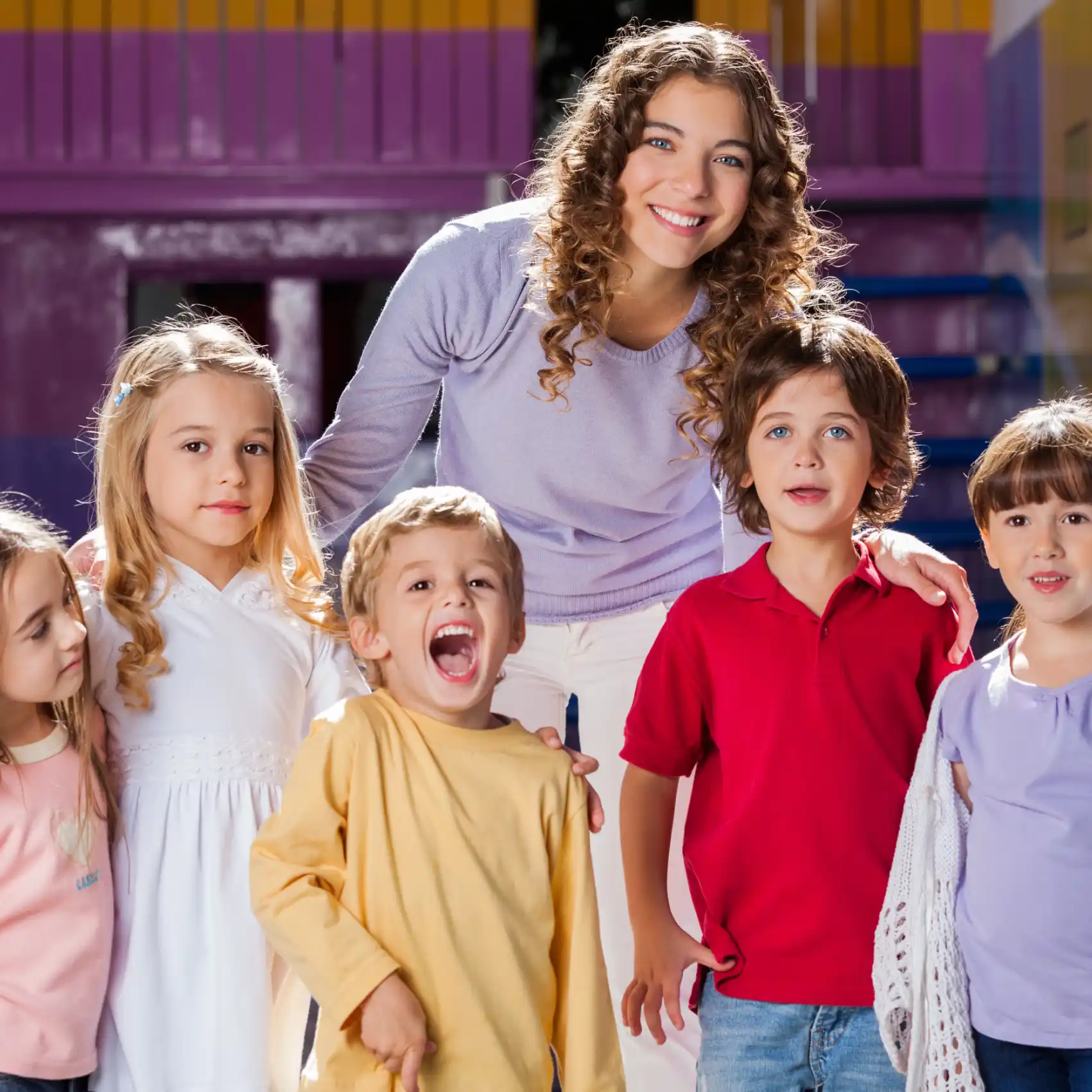 Maestra con sus alumnos sonriendo y utilizando pedagogia sistémica.